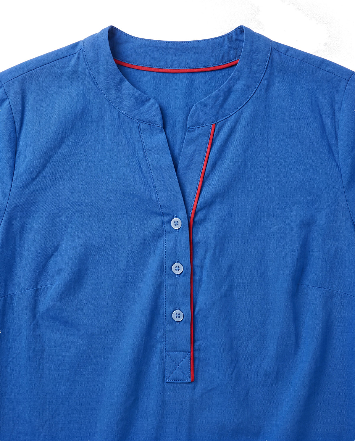 Close up of the notch neckline, three button placket and red contrast trim