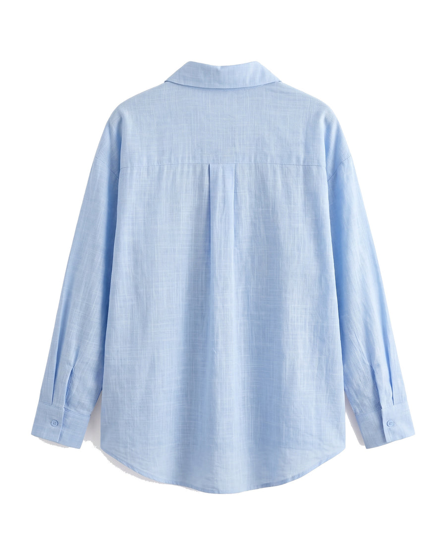 Blue oversized button-down shirt, back view with yoke and curved hem