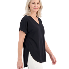 Model wearing the black loose V neck top, three quarter view showing the side slit